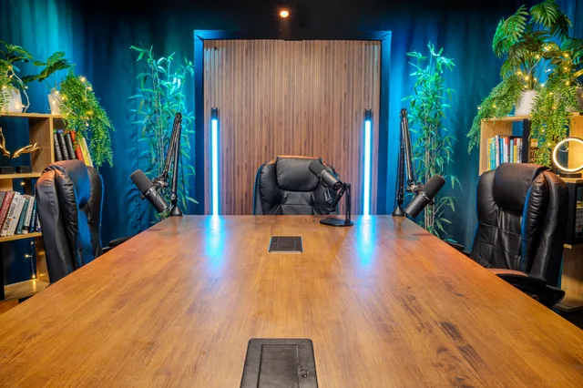 The Great Boardroom set for a recording, microphones on boom arms around the table